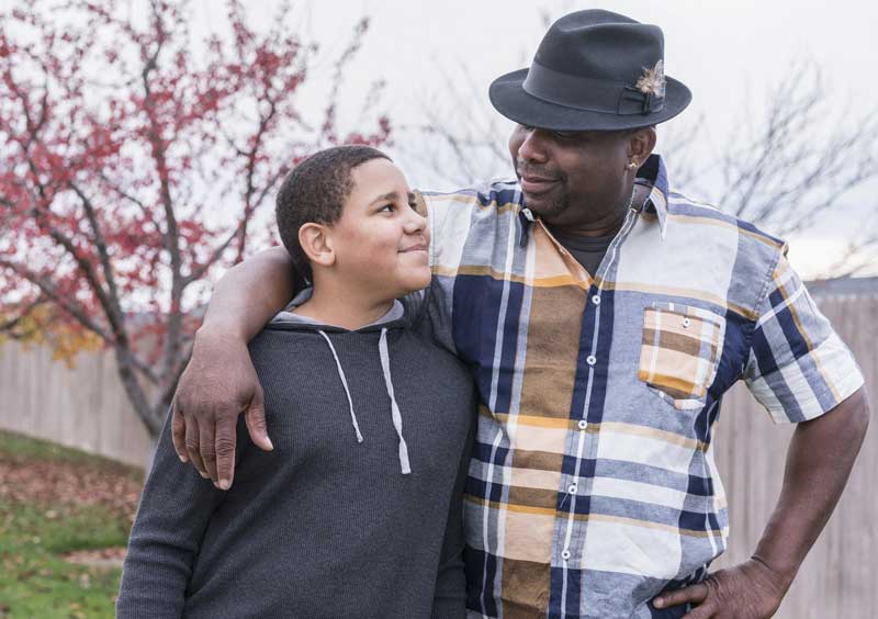 Un hombre de color y su hijo de la mano