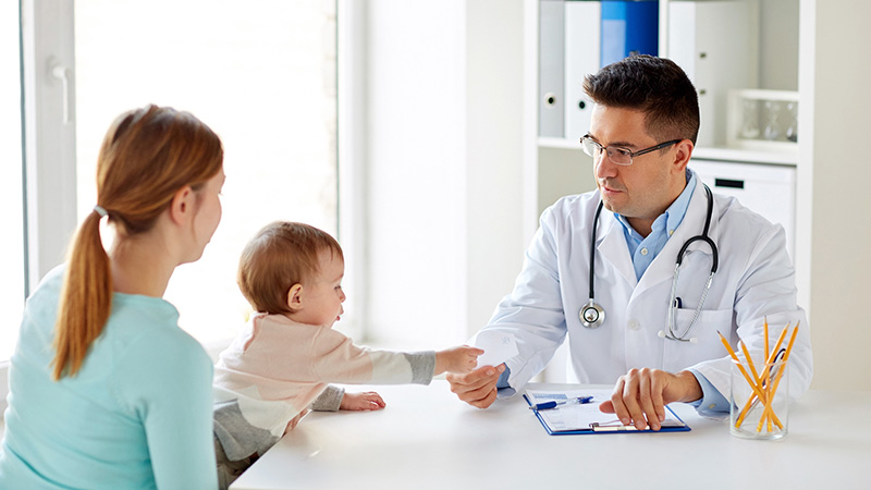 Doctor hablando con madre y bebé