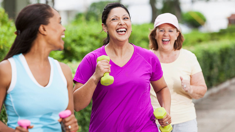 women jogging through a park