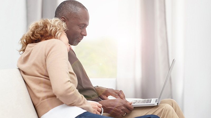 pareja mirando la pantalla de una computadora portátil