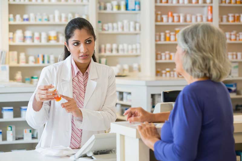 Farmacéutico que explica los medicamentos al cliente