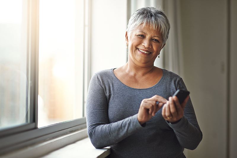 mujer mayor feliz en un teléfono inteligente