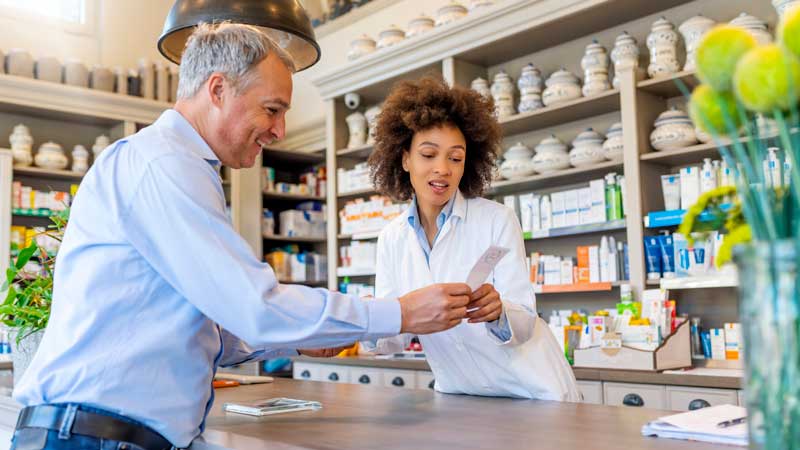 hombre hablando con farmacéutico sobre la receta