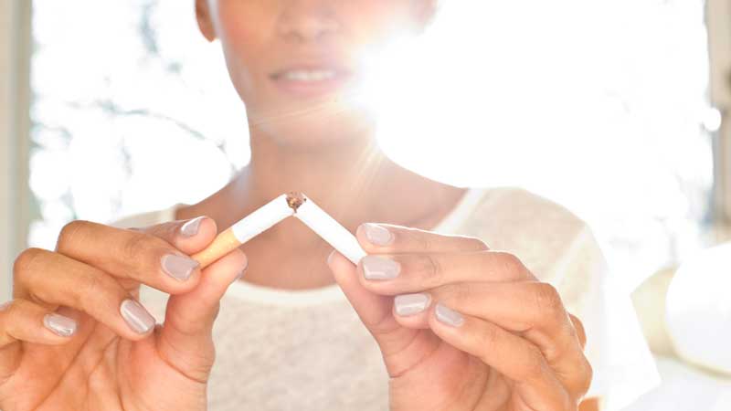 woman breaking a cigarette with her hands