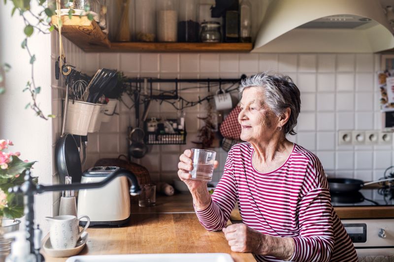 Elderly woman holding a glass of water