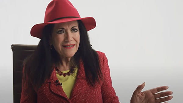 Captura de pantalla de video de Claudia Montano, sobreviviente de ataque o derrame cerebral, sentada en una silla frente a un fondo neutro