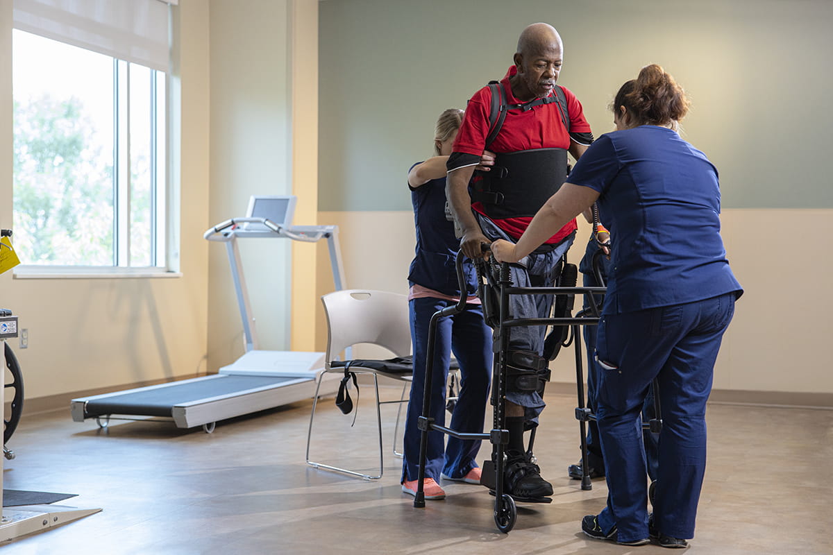 Man on walker assisted by nurse