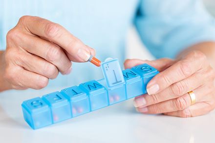 woman hands placing pills in sorter woman hands placing pills in sorter