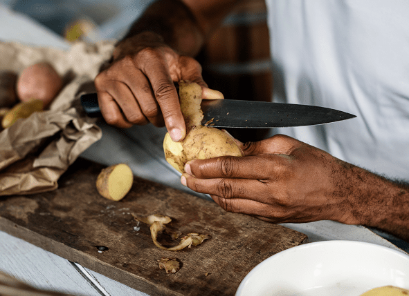 close up of someone peeling potatoes