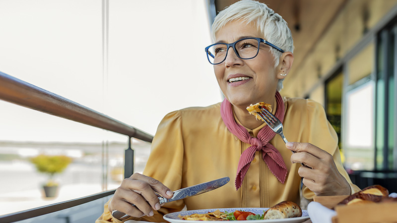 A senior woman is smiling while eating a balanced meal. A senior woman is smiling while eating a balanced meal.