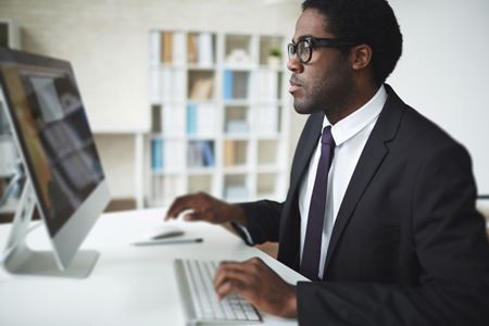 Adult working at a laptop in an office setting