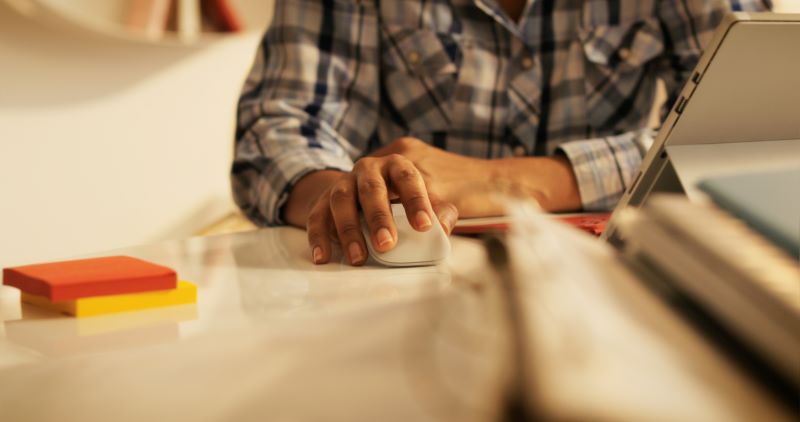Senior Woman using a mouse and working on lap top