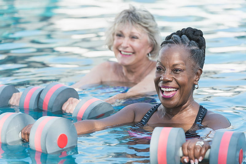 a senior Black woman and friend doing water aerobics a senior Black woman and friend doing water aerobics