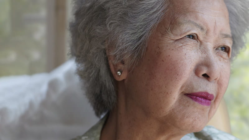 Chinese woman sitting in front of a window post-stroke