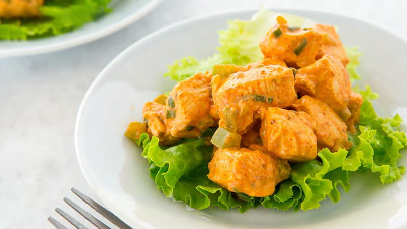 a plate of cubed chicken on a bed of lettuce a plate of cubed chicken on a bed of lettuce