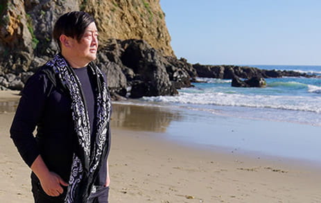 Stroke survivor, Dave Kim, is walking along the beach.