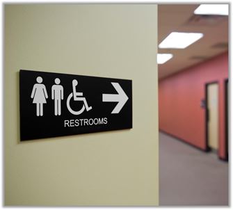 office hallway with a sign showing female, male, and wheelchair icons, and an arrow pointing to the restrooms office hallway with a sign showing female, male, and wheelchair icons, and an arrow pointing to the restrooms