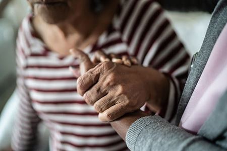 caregiver holding a senior woman's hand to provide support caregiver holding a senior woman's hand to provide support