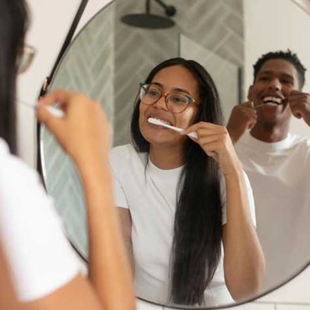 Couple brushing and flossing together