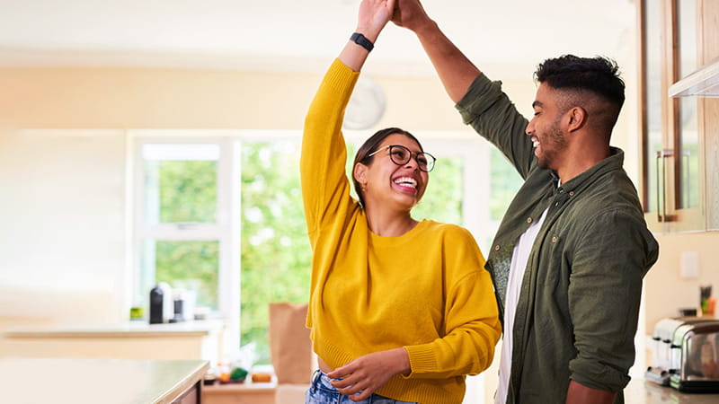 Una pareja joven baila en su cocina Una pareja joven baila en su cocina