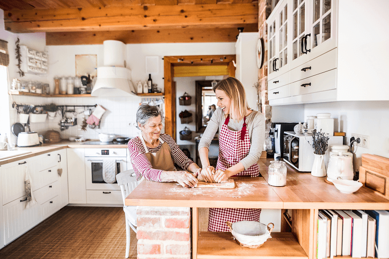 elderly adult cooking with family member